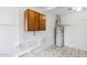Well-maintained basement with a water heater, a cabinet, white-painted pipes, and tiled floors at 8629 E Cambridge Ave, Scottsdale, AZ 85257