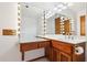 Spacious bathroom featuring a vanity with Hollywood-style lighting, wood cabinets, and ample counter space at 8629 E Cambridge Ave, Scottsdale, AZ 85257