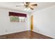 This bedroom features hardwood floors, ceiling fan and a window with blinds, providing natural light and ventilation at 8629 E Cambridge Ave, Scottsdale, AZ 85257