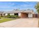 View of the home showcasing the long driveway and covered parking, brick accents, and well-maintained exterior at 8629 E Cambridge Ave, Scottsdale, AZ 85257