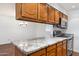 Kitchen shows marble countertops, wooden cabinets, stainless steel oven and range and open view to dining area at 8629 E Cambridge Ave, Scottsdale, AZ 85257