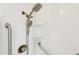 Updated shower featuring multiple showerheads, grab bars and built-in storage in a bright, white space at 8629 E Cambridge Ave, Scottsdale, AZ 85257