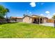 Spacious backyard featuring lush green grass, a trampoline, and a covered patio area at 8741 W Manzanita Dr, Peoria, AZ 85345