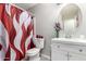 Bathroom featuring a white vanity, an oval mirror, a toilet, and a patterned shower curtain at 8741 W Manzanita Dr, Peoria, AZ 85345