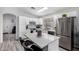 Bright kitchen featuring white cabinetry, stainless steel appliances, and a functional island with barstool seating at 8741 W Manzanita Dr, Peoria, AZ 85345