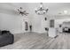 Spacious living room with hard surface flooring, a modern ceiling fan, and an open entryway to other areas of the home at 8741 W Manzanita Dr, Peoria, AZ 85345