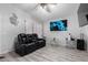 Stylish living room showcasing wood-look tile floors, sleek furniture, and a large mounted television at 8741 W Manzanita Dr, Peoria, AZ 85345