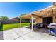 Inviting covered patio with dining and lounge seating, overlooking the expansive backyard at 8741 W Manzanita Dr, Peoria, AZ 85345