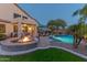 A backyard with a pool, fire pit, and covered patio creates the perfect outdoor retreat at 9443 E Mallory St, Mesa, AZ 85207