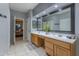 Bathroom featuring double sinks and a large mirror, with a view into the bedroom at 9443 E Mallory St, Mesa, AZ 85207