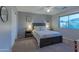 Cozy bedroom boasts a queen-sized bed with two nightstands, carpeting, and a bright window at 9443 E Mallory St, Mesa, AZ 85207
