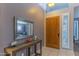 Inviting entryway with a decorative table, modern mirror, and a solid wood front door at 9443 E Mallory St, Mesa, AZ 85207