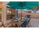 Inviting outdoor dining area with a wooden table, seating for six, and an umbrella for shade at 9443 E Mallory St, Mesa, AZ 85207