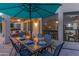 Inviting outdoor dining area with a wooden table, seating for six, and an umbrella for shade at 9443 E Mallory St, Mesa, AZ 85207