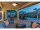 Resort-style backyard with a sparkling pool, lounge chairs, patio seating, and lush landscaping at 9443 E Mallory St, Mesa, AZ 85207