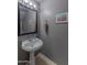 Stylish powder room featuring a pedestal sink, framed mirror, and neutral decor at 9443 E Mallory St, Mesa, AZ 85207