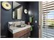 Modern powder room with a unique vessel sink, dark walls, and a window with a scenic view at 9643 E Legacy Ridge Rd, Scottsdale, AZ 85262