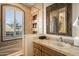 Bright bathroom featuring tile walls, arched window, a bathtub, and a vanity with sink at 9643 E Legacy Ridge Rd, Scottsdale, AZ 85262