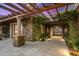 Exterior shot showcasing stonework, an arbor, and manicured landscaping leading to the gated entrance at 9643 E Legacy Ridge Rd, Scottsdale, AZ 85262