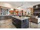 Open kitchen with a large island, bar seating, and a view into the living area with fireplace at 9643 E Legacy Ridge Rd, Scottsdale, AZ 85262