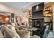 Open living room with fireplace, sofas, and access to dining room, all with plenty of natural light at 9643 E Legacy Ridge Rd, Scottsdale, AZ 85262