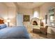 A cozy main bedroom features a fireplace and a plush chaise lounge creating an inviting retreat at 9643 E Legacy Ridge Rd, Scottsdale, AZ 85262
