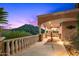 Covered outdoor patio with stone columns and railings, showcasing stunning mountain views at sunset at 9643 E Legacy Ridge Rd, Scottsdale, AZ 85262