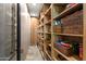 Walk-in pantry with wooden shelving and ample storage space for food and kitchen supplies at 9643 E Legacy Ridge Rd, Scottsdale, AZ 85262