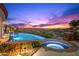 Beautiful pool and hot tub with serene views of the desert and colorful sunset at 9643 E Legacy Ridge Rd, Scottsdale, AZ 85262