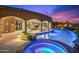 Outdoor entertainment space featuring a pool and spa with colorful lights on a desert evening at 9643 E Legacy Ridge Rd, Scottsdale, AZ 85262