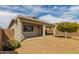 View of the backyard with a covered patio, gravel landscaping, and a privacy wall at 9733 W Purdue Ave, Peoria, AZ 85345