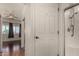 Bathroom with a white door leading to a shower, and a view into a bedroom with wood floors at 9733 W Purdue Ave, Peoria, AZ 85345