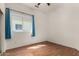 Cozy bedroom features hardwood floors and a large window, offering ample natural light and a serene view at 9733 W Purdue Ave, Peoria, AZ 85345