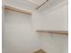 Walk-in closet features white shelves and wooden rods, providing an organized storage solution at 9733 W Purdue Ave, Peoria, AZ 85345