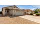 Beige single-story home featuring a two-car garage and low-maintenance gravel landscaping at 9733 W Purdue Ave, Peoria, AZ 85345