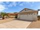Beige single-story home featuring a two-car garage and low-maintenance gravel landscaping at 9733 W Purdue Ave, Peoria, AZ 85345