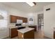 Kitchen with center island, light countertops, and dark wood cabinets at 9733 W Purdue Ave, Peoria, AZ 85345