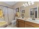 Bright bathroom featuring a double sink vanity with oak cabinets and a shower-tub combo at 9954 W Mohawk Ln, Peoria, AZ 85382