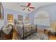 Bedroom featuring a queen bed, hardwood floors, decor and a red ceiling fan at 9954 W Mohawk Ln, Peoria, AZ 85382