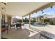 Inviting covered patio features a dining area overlooking the lush backyard pool and landscaping at 9954 W Mohawk Ln, Peoria, AZ 85382