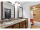 Bathroom with double sinks, granite counters, and a tiled shower, combining functionality and style at 10484 E Mission Ln, Scottsdale, AZ 85258