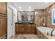 Stunning primary bathroom showcasing double sinks, granite counters, tile accents, and a soaking tub at 10484 E Mission Ln, Scottsdale, AZ 85258