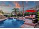 Beautiful pool with lounge area and an outdoor fireplace, creating a luxurious and serene backyard oasis at 10484 E Mission Ln, Scottsdale, AZ 85258