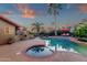 Inviting backyard pool with lush landscaping and charming outdoor fireplace for relaxing evenings at 10484 E Mission Ln, Scottsdale, AZ 85258