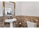 Elegant powder room with designer finishes, a pedestal sink, and decorative wall tiles at 10484 E Mission Ln, Scottsdale, AZ 85258
