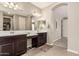 Well-lit bathroom with double sinks, dark wood cabinets, and a large mirror at 1078 W Redwood Ave, Queen Creek, AZ 85140