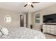 Bright bedroom with a ceiling fan, oval mirror, and a dresser with a TV on top at 1078 W Redwood Ave, Queen Creek, AZ 85140