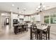 Bright kitchen with modern lighting, an island with bar seating, and an adjacent dining area at 1078 W Redwood Ave, Queen Creek, AZ 85140