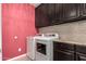 A clean laundry room area with front loading machines, overhead cabinets, and a countertop at 1078 W Redwood Ave, Queen Creek, AZ 85140