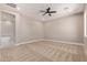 Carpeted bedroom with ceiling fan, neutral walls, and an adjacent bathroom at 1244 N 106Th Pl, Mesa, AZ 85207